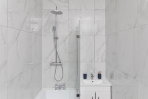 a white bathroom with a shower and a sink at Harewood Lodge Darlington Luxury Apartments in Darlington