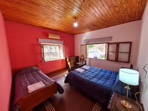 una camera con due letti e pareti rosse di Mis Marias a Villa Unión