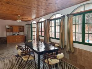 una sala da pranzo con tavolo, sedie e finestre di Mis Marias a Villa Unión