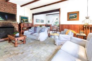 een woonkamer met witte meubels en een open haard bij Refugio Na Serra, 5Qts Vista Mata Atlantica in Teresópolis