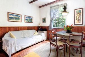 een woonkamer met een witte bank en een tafel bij Refugio Na Serra, 5Qts Vista Mata Atlantica in Teresópolis
