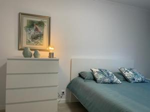 1 dormitorio con 1 cama y una foto en la pared en Pópulo Mar en Ponta Delgada