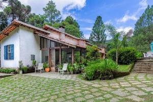 een huis met een tuin ervoor bij Refugio Na Serra, 5Qts Vista Mata Atlantica in Teresópolis
