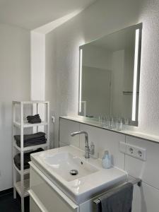 a white bathroom with a sink and a mirror at Ferienwohnung Schmied von Almertsham in Höslwang