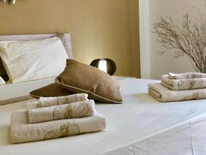 a white bed with three folded towels on it at Montellinos Suite Tortora in SantʼAntìoco