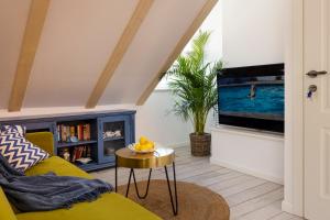 a living room with a yellow couch and a tv at Stayeva 11 in Dubrovnik