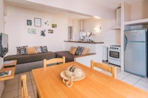 cocina y sala de estar con mesa y sofá en Riviera Fueguina Apartments en Ushuaia