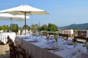 una mesa con un mantel blanco y una sombrilla en Agriturismo Cavazzone, en Regnano