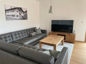 a living room with a couch and a table and a tv at Ferienwohnung Schmied von Almertsham in Höslwang