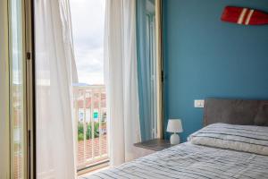 ein Schlafzimmer mit einem Bett und einem großen Fenster in der Unterkunft Pretty house in Viareggio