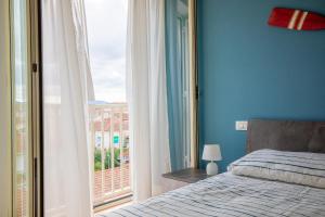 a bedroom with a bed and a large window at Pretty house in Viareggio