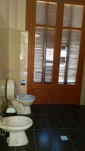 a bathroom with a toilet and a door with windows at Posada Del Gaucho in Montevideo