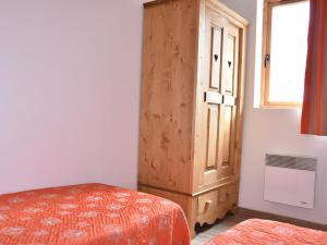 a bedroom with a wooden cabinet next to a bed at Appartement 2 Pièces avec Piscine Chauffée, Balcon, Parking et Proche Centre à Pralognan - FR-1-464-160 in Pralognan-la-Vanoise