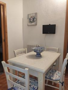 una mesa blanca con sillas y un tazón en ella en Appartamento a 50 mt dal mare en Cala Gonone