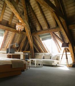 a large attic room with a bed and a couch at Auberge d'Etoy in Rolle