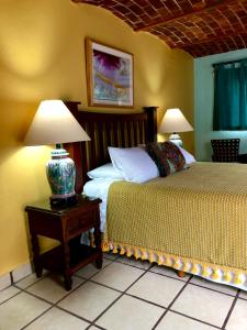 a bedroom with two beds and a table with two lamps at Casa del Sol Inn in Ajijic