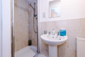 a bathroom with a sink and a shower at MODERN 2 BEDROOM 2 BATHROOM APARTMENT SLEEPS 4 IN WARRINGTON FOR WORK AND LEISURE WITH PRIVATE PARKING BY AMAZING SPACES RELOCATIONS Ltd in Warrington