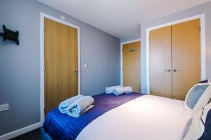ein Schlafzimmer mit einem Bett mit Handtüchern darauf in der Unterkunft MODERN 2 BEDROOM 2 BATHROOM APARTMENT SLEEPS 4 IN WARRINGTON FOR WORK AND LEISURE WITH PRIVATE PARKING BY AMAZING SPACES RELOCATIONS Ltd in Warrington + 12 Fotos