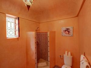 een badkamer met een douche, een toilet en een raam bij Riad Princesse Du Désert & Spa in Marrakesh