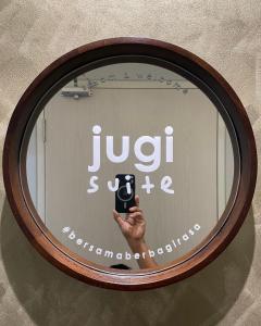 uno specchio con una mano che tiene un cellulare di jugi suite @ Horizon Sepang KLIA a Sepang