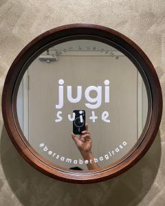 a mirror with a hand holding a cell phone at jugi suite @ Horizon Sepang KLIA in Sepang