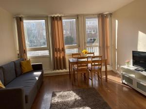 a living room with a couch and a table and chairs at 2-bedroom Flat in Regents Park-Euston-Camden in London