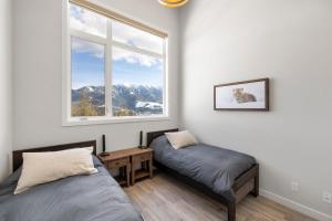 1 dormitorio con 2 camas y ventana en Falling Star Ski House en Fernie