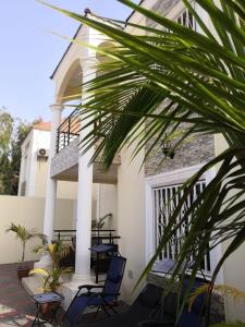 Amdalai的住宿－Janha's Senegambia Villa Holiday Rental With Free Wifi，一个带椅子和阳台的房屋门廊