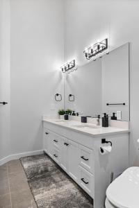 a white bathroom with a sink and a mirror at Falling Star Ski House in Fernie