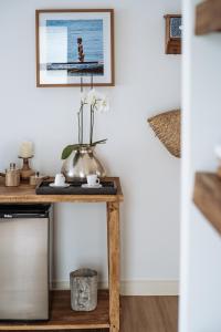 une table dans un salon avec une photo sur le mur dans l'établissement Vila Dos Orixás Boutique Hotel, à Morro de São Paulo