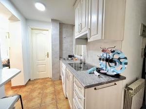 una cucina con mobili bianchi e un piano di lavoro di Encantador Piso Zamora Temporal a Madrid Altre 30 foto