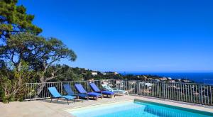 Villa Crystal River, piscine privée & vue mer sur Golfe de Saint Tropez في Saint-Peïre-sur-Mer: حمام سباحة مع الكراسي والمحيط في الخلفية