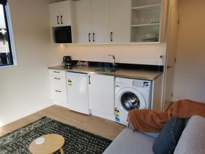 a kitchen with a washer and a washing machine at Studio 4 - NEW & Central in Hanmer Springs