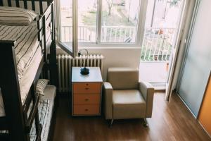 a room with a chair and a desk and a bed at Smart hostel in Belgrade