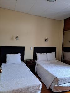 Residencial Aviz في كويمبرا: سريرين في غرفة فندق بسريرين