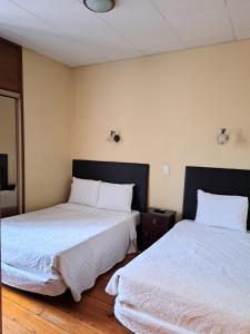 Residencial Aviz في كويمبرا: سريرين يجلسون بجانب بعض في غرفة