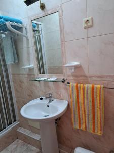 W łazience znajduje się umywalka i lustro. w obiekcie Residencial Aviz w mieście Coimbra