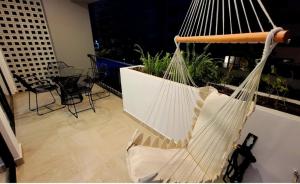 a swinging hammock in a room with a window at IYARI 2 bdr Apartment in Nuevo Vallarta