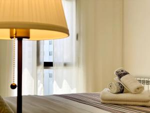een slaapkamer met een bed met handdoeken en een lamp bij Airport Expo Apartment in Lissabon