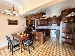 uma cozinha com armários de madeira e uma mesa e cadeiras de madeira em Antonios House Ithaka em Vathi