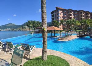a large swimming pool with chairs and a resort at PEDAÇO DO PARAÍSO in Angra dos Reis