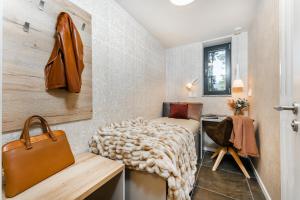um pequeno quarto com uma cama e uma secretária em Apartament A121 Molo Lipno s infrasaunou - Residence Koubek em Lipno nad Vltavou