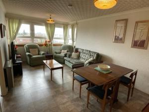 uma sala de estar com um sofá e uma mesa em West End Hidden Gem - Modern 2-Bedroom Apartment with residents patio em Anniesland