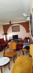 a living room with a couch and a table and chairs at Appartement Amilcar in Dar Salah Bey