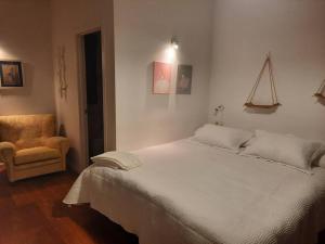 1 dormitorio con 1 cama blanca grande y 1 silla en A casa do Val, en Lugo