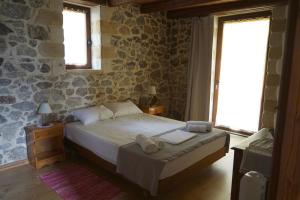 1 dormitorio con 1 cama con toallas en Elpida Country House -Paleochora-Anidri, en Palaiochóra