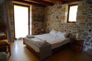 a bedroom with a bed in a room with stone walls at Elpida Country House -Paleochora-Anidri in Palaiochora