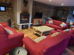 una sala de estar con sofás rojos y una mesa. en A casa do Val en Lugo