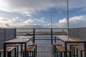 a balcony with tables and chairs and a view of the ocean at RESIDENCY LUXURY SEAFRONT HOTEL in Blackpool