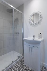 a bathroom with a shower and a sink and a mirror at RESIDENCY LUXURY SEAFRONT HOTEL in Blackpool